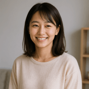 整理された室内で、淡いグレー背景を背に軽く笑う日本人女性の写真風イメージ